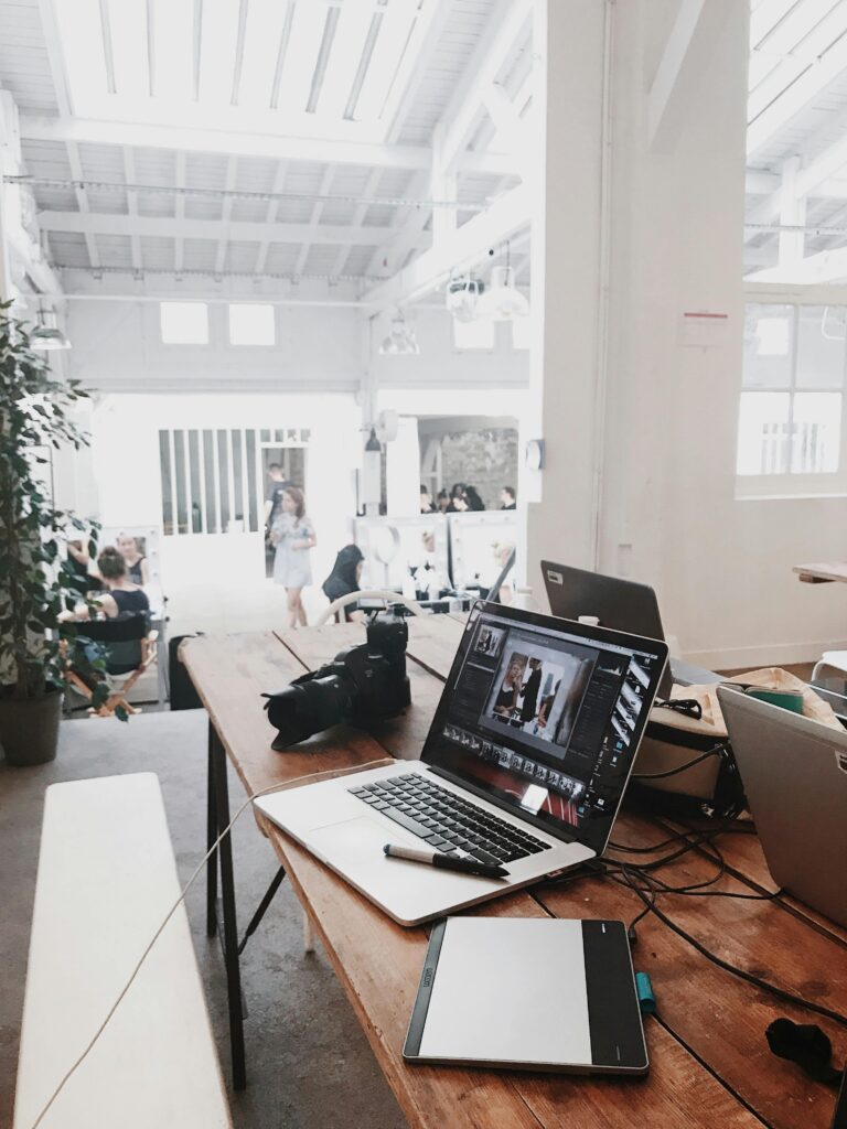 pexels-photo-699459-699459-1 A bright, modern workspace featuring laptops, a camera, and a drawing tablet in an indoor office.